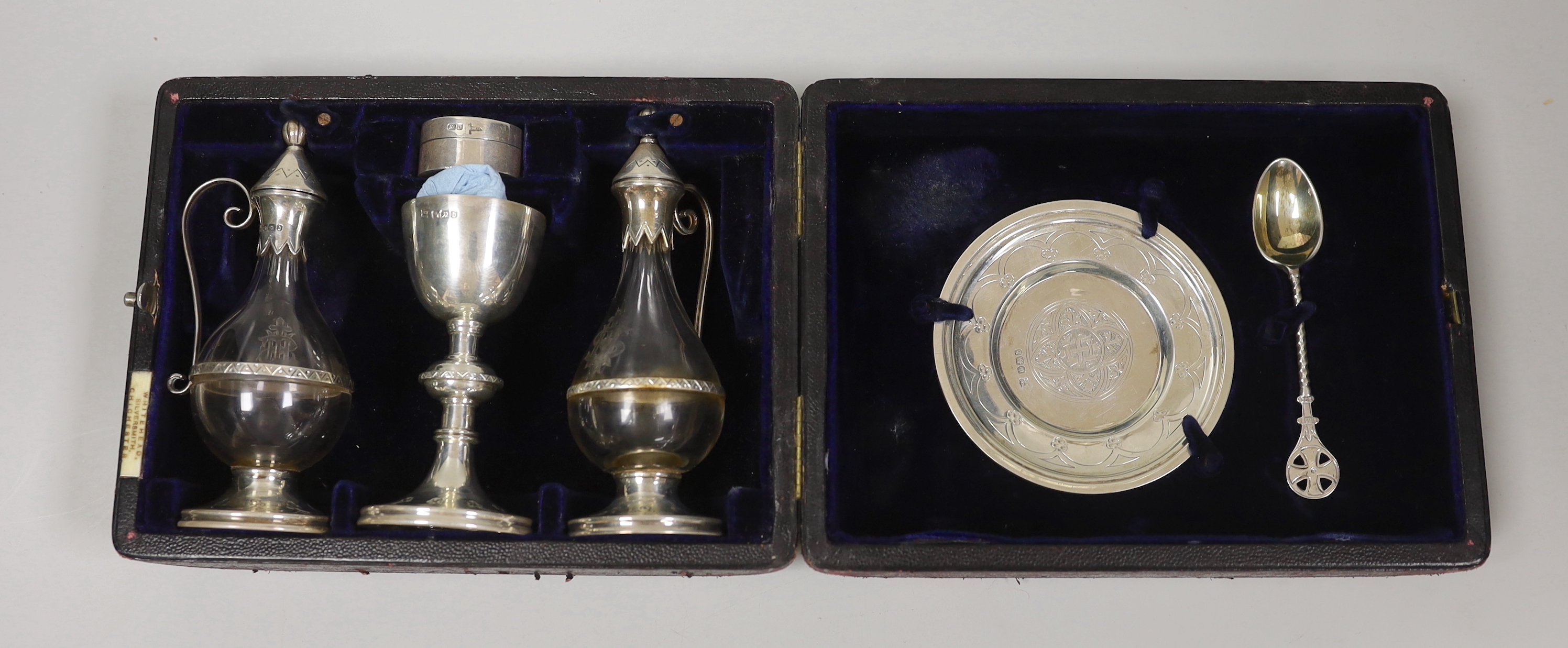 A cased late Victorian four piece silver communion set, Henry Wilkinson & Co Ltd, Sheffield, 1894, together with a matched wafer box and spoon, Walker & Hall, 1904/1906.